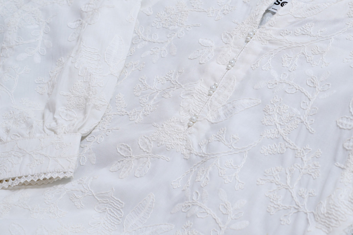 White chikankari cotton kids kurti with embroidered texture, full sleeves, lace-trim hem, and round neckline — handcrafted Pakistani kids clothing.