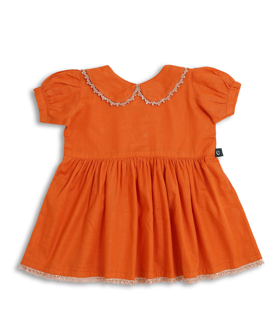 Orange cotton khaddar girls frock and trouser set with lace-trim Peter Pan collar, gathered waist, and delicate hem—Pakistani kids clothing