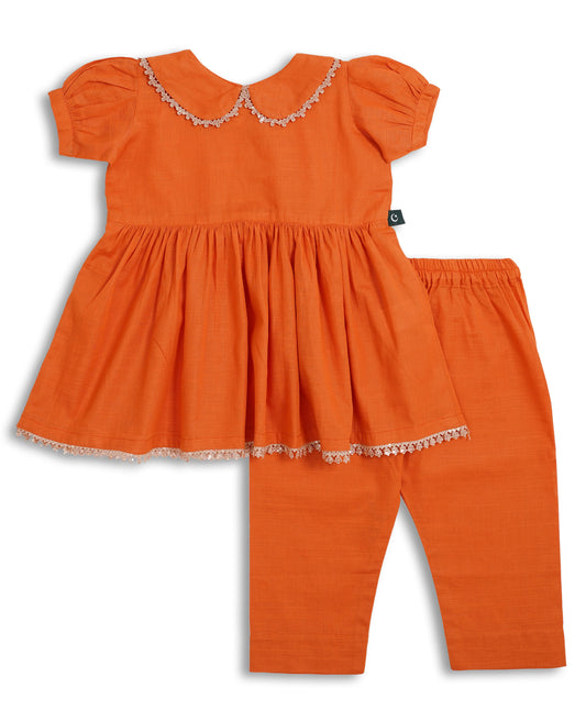 Orange cotton khaddar girls frock and trouser set with lace-trim Peter Pan collar, gathered waist, and delicate hem—Pakistani kids clothing